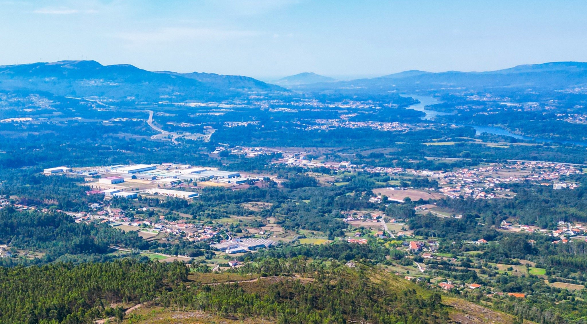 Vista panorâmica de Valença, mostrando áreas urbanas e rurais rodeadas por colinas e vegetação, ilustrando o território atrativo referido no artigo.